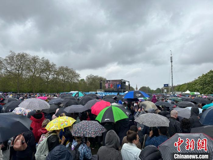 當?shù)貢r間5月6日，英國國王查爾斯三世的加冕儀式舉行。民眾雨中觀看儀式。　歐陽開宇 攝