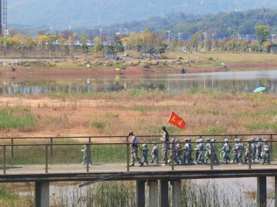 　　10月24日，秋游的幼兒園小朋友在老師帶領(lǐng)下走在清水塘公園里的木橋上。本報(bào)記者 常雯宜攝