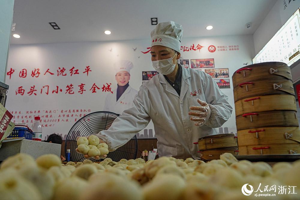 3月31日，在浙江省嵊州市甘霖鎮(zhèn)，嵊州小吃從業(yè)者沈紅平把蒸熟的小籠包晾涼，打包冷藏售賣(mài)。人民網(wǎng) 章勇濤攝