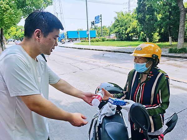 何超為過路的老人送上礦泉水和冷飲。人民網(wǎng)記者 王繼亮攝