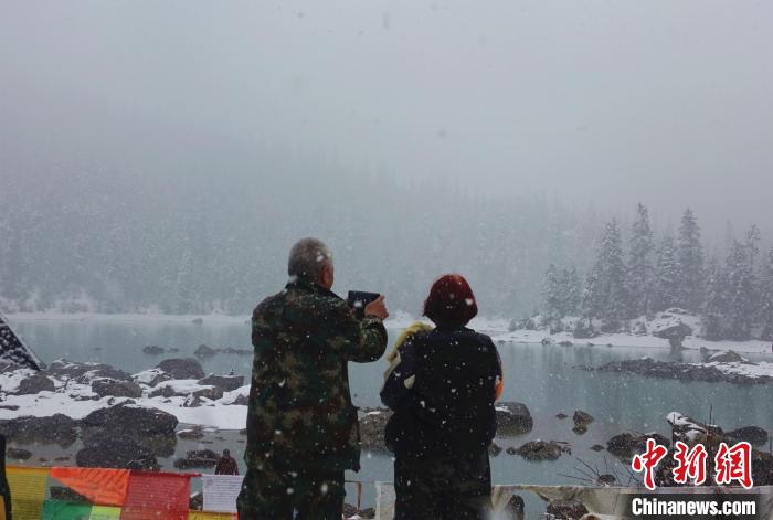 游客欣賞雪中然烏湖。　冉文娟 攝