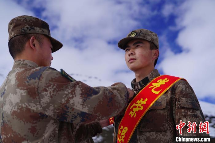 排長(zhǎng)王朝偉(圖左)給退伍老兵佩戴大紅花?！∥鞑厣侥宪姺謪^(qū)某團(tuán)供圖