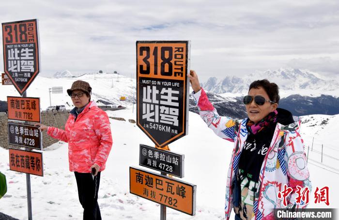 圖為5月14日，西藏林芝色季拉山觀景臺(tái)，游客與南迦巴瓦峰合影?！±盍?攝