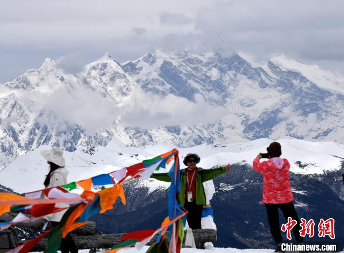 圖為5月14日，西藏林芝色季拉山觀景臺(tái)，游客與南迦巴瓦峰合影?！±盍?攝