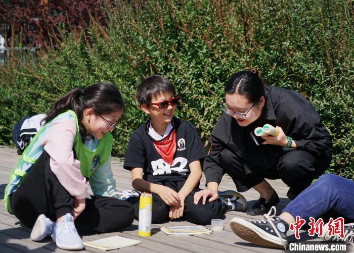 圖為小朋友在青海西寧湟水國家濕地公園內(nèi)認識植物并進行繪畫?！●R銘言 攝