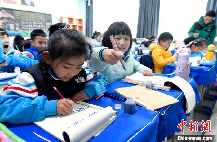 3月14日，西藏拉薩市第一小學(xué)一年級六班學(xué)生白瑪朗珍(圖左)在藏語文課上書寫藏文?！±盍?攝