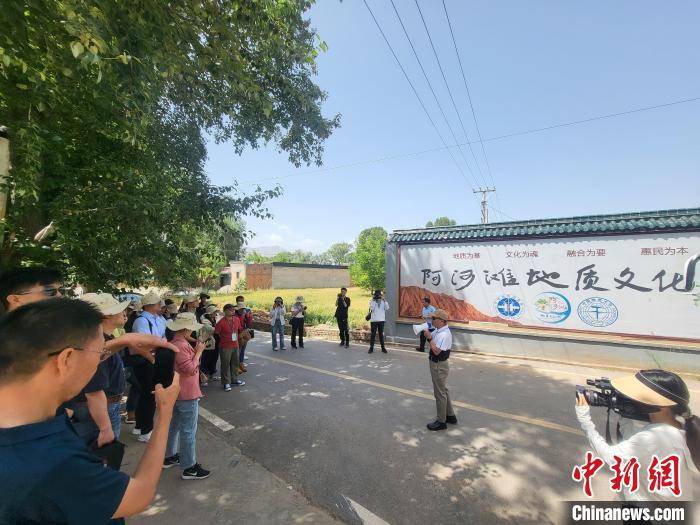 圖為中國(guó)地質(zhì)大學(xué)(北京)教授張緒教介紹村落情況?！『衍?攝