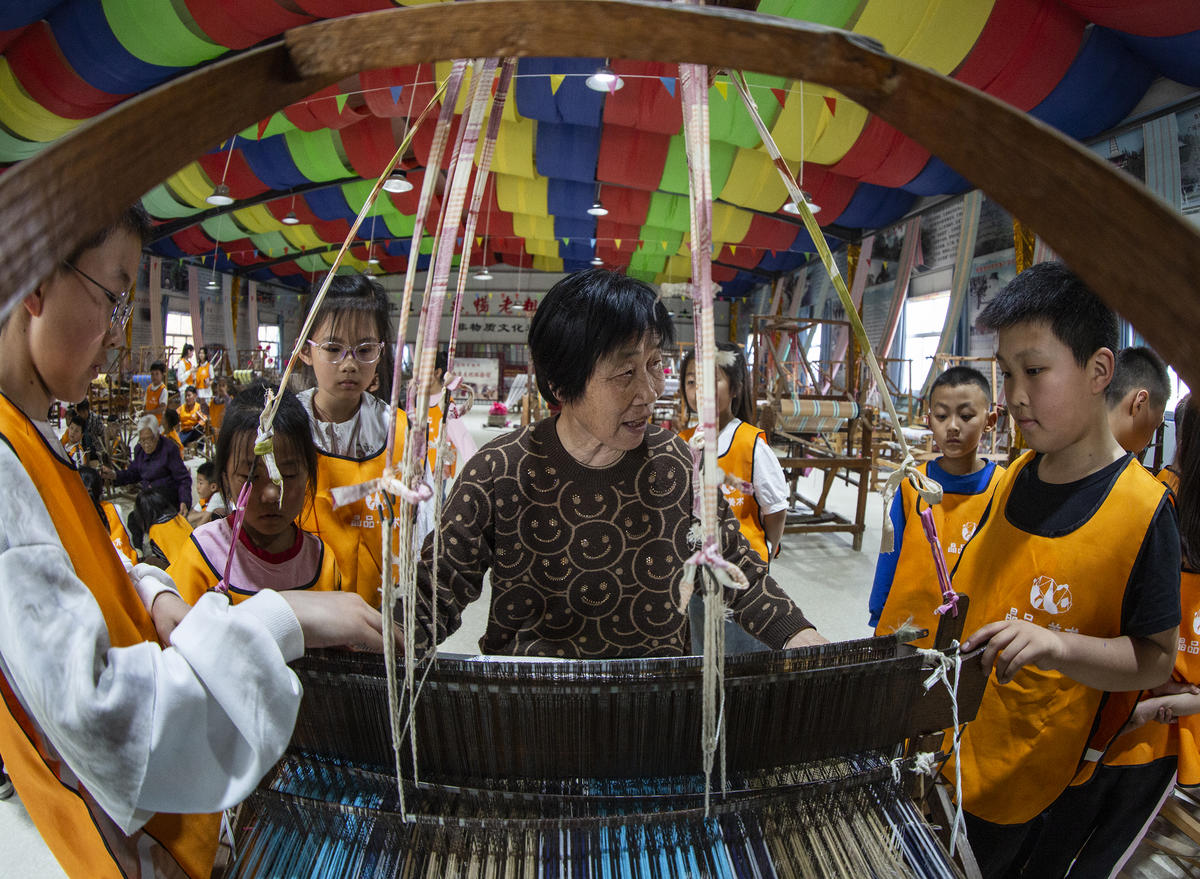 5月1日，在山西省永濟市開張鎮(zhèn)東開張村的惠暢土布文化園，土布制作技師教游客織布技藝。 來源：人民圖片網(wǎng)