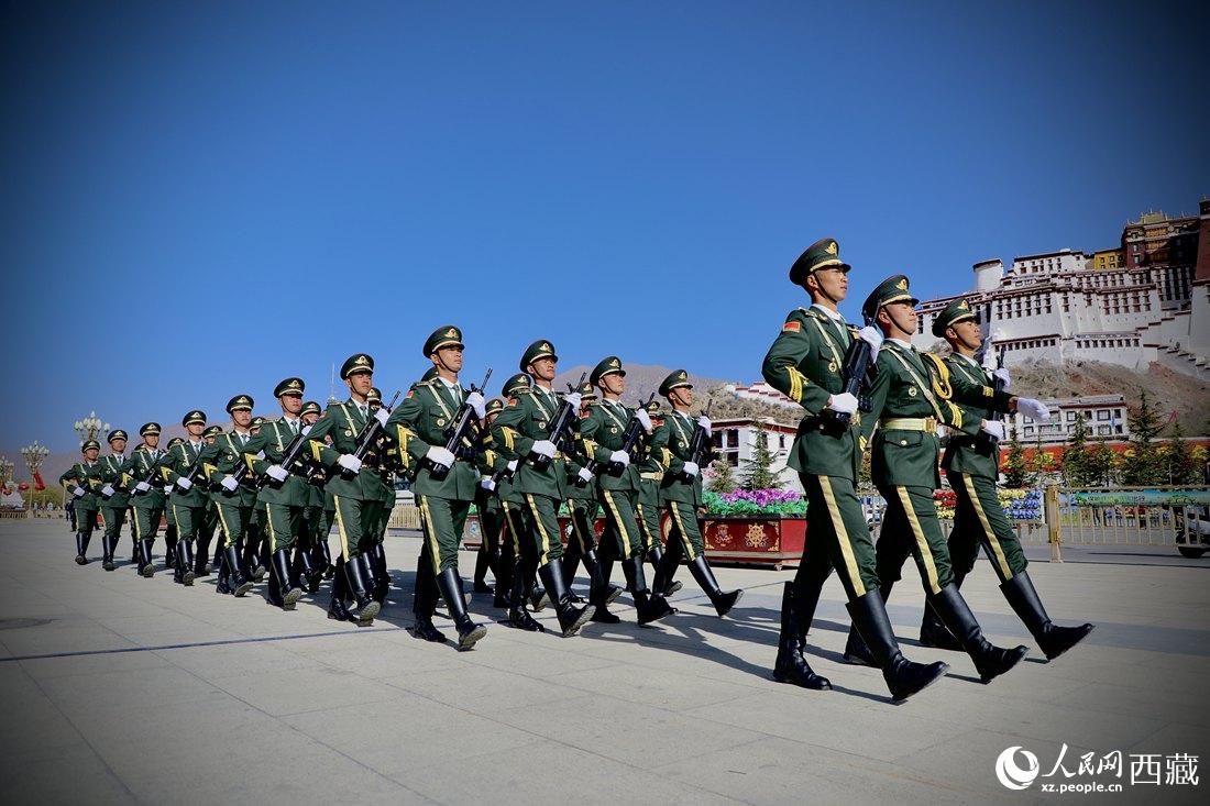 國旗護(hù)衛(wèi)隊隊員緊握鋼槍，踏著威武雄壯的步伐，走向國旗臺。人民網(wǎng) 次仁羅布攝