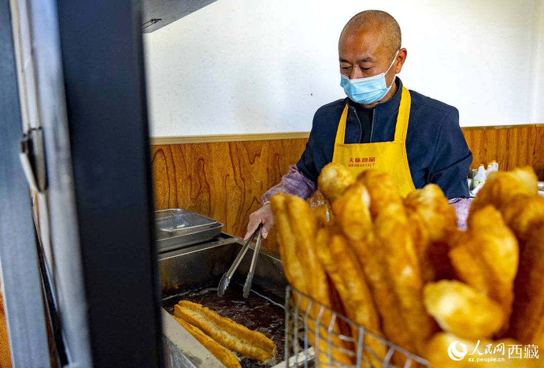 早餐店老板正在炸油條。人民網(wǎng) 次仁羅布攝