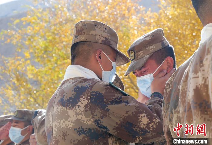 圖為什布奇邊防連退伍老兵與戰(zhàn)友相擁而泣，依依惜別。　徐昌成 攝