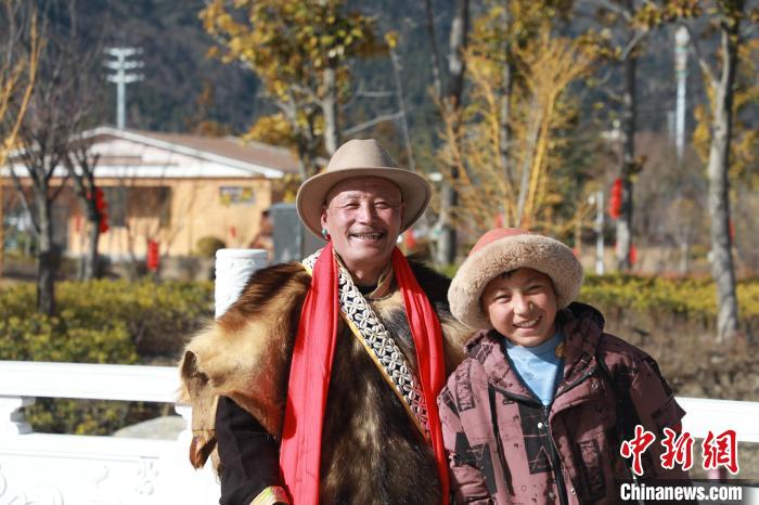 圖為林芝市巴宜區(qū)布久鄉(xiāng)仲果村村民桑杰與孫子一起參加藏歷新年活動(dòng)?！埩?攝