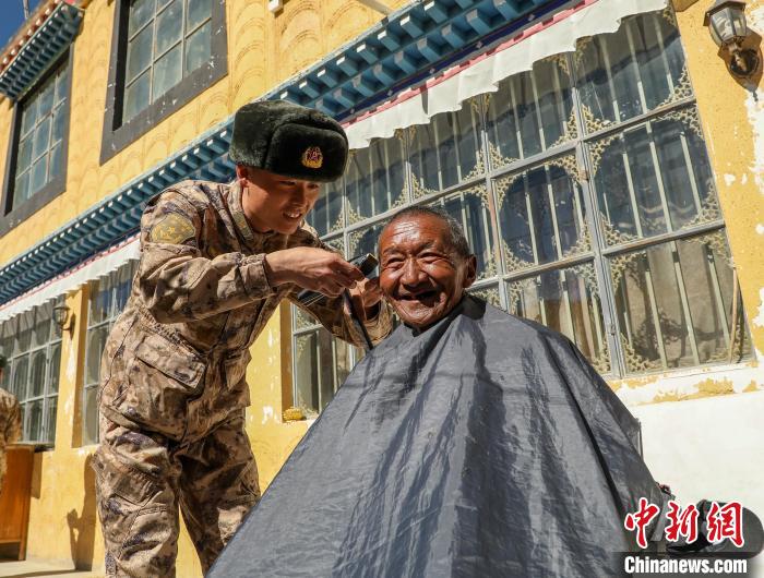 圖為阿里軍分區(qū)某邊防團(tuán)官兵為駐地群眾理發(fā)迎藏歷新年。　旦增倫珠 攝