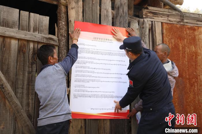 圖為亞東邊檢站民警與駐地邊民群眾共同張貼國(guó)家安全知識(shí)教育海報(bào)?！問|邊檢站 供圖